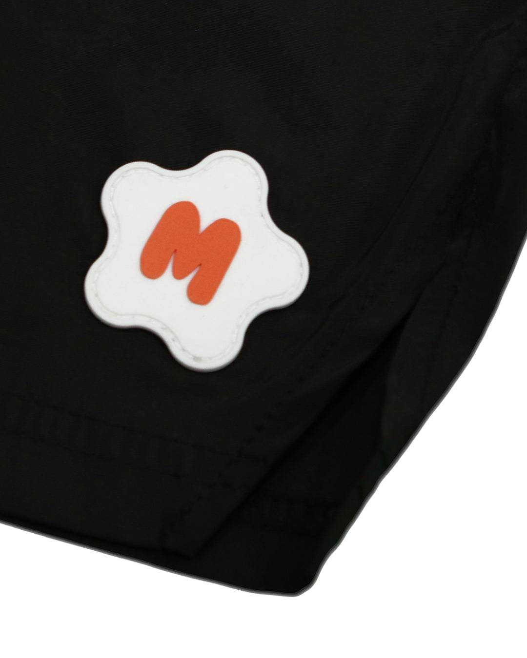 Black nylon shorts with rubber logo detail on the left leg.